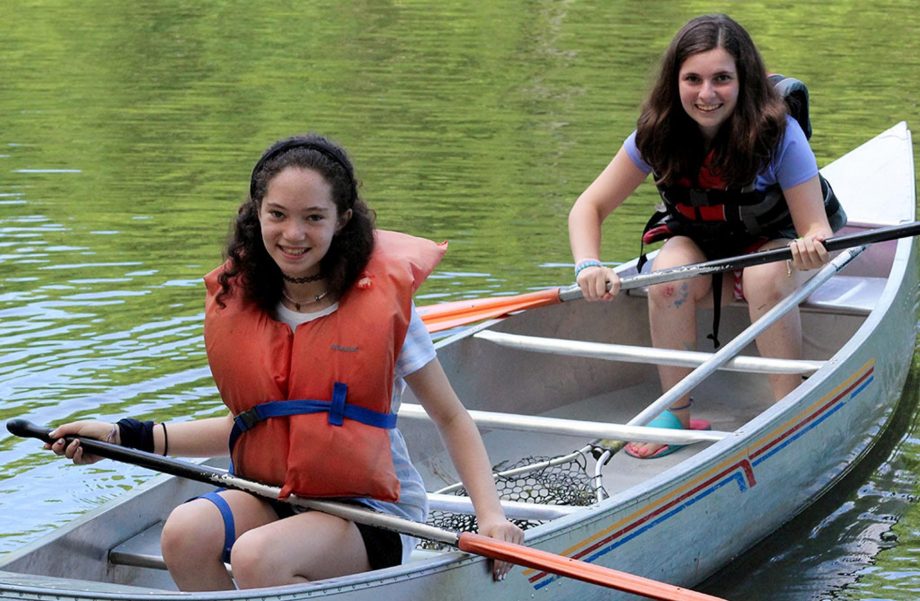 Two girls canoeing on lake
