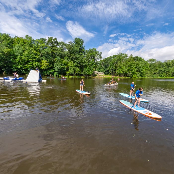 campers paddleboarding on lake