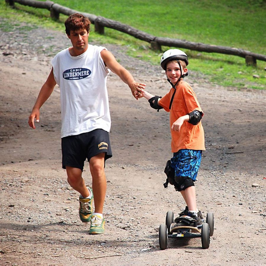 Staff helping camper on mountain board