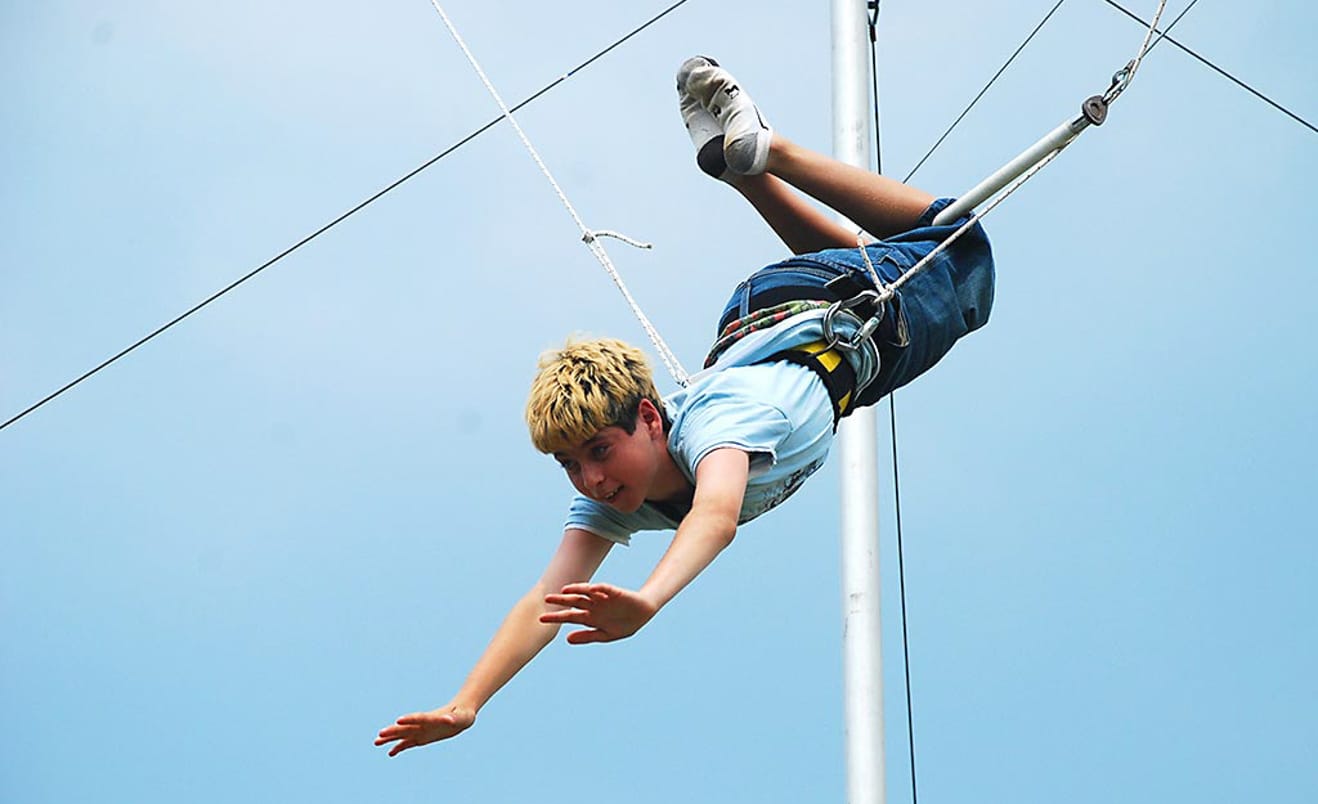 Male camper on flying trapeze